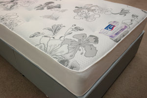 The Ortho Pocket 1024 Mattress, corner view shows a bold grey floral pattern on the white heavy duty stretch knit fabric with tufts. It is turnable, having superior damask fabric on the reverse side & stitched border. The luxury fillings on top of toughened orthopaedic pocket springs gives a medium feel