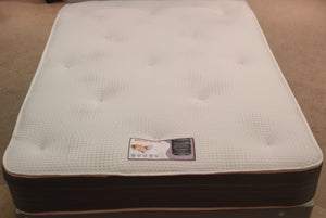 This top view of the Kensington Memory Spring Mattress shows the heavy duty stretch knit fabric with tufts, which is over the 2" Memory foam. The border is in a Dark Grey Polka Dot fabric. It is turnable for dual seasons, with a white damask fabric on the medium tension reverse side. All supported by a 13.5 gauge Bonnell Sping unit with rod edge for extra strength.