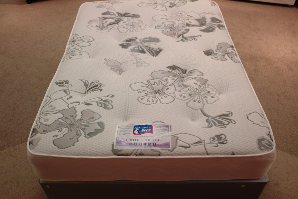 The Ortho Pocket 1024 Mattress, top view shows a bold grey floral pattern on the white heavy duty stretch knit fabric with tufts. It is turnable, having superior damask fabric on the reverse side & border. The luxury fillings on top of toughened orthopaedic pocket springs gives a medium feel