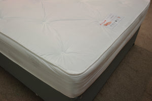 This corner view of the Luxury Ortho Spring Mattress highlights the 9” border which is in white quilted damask fabric. Both sides of the mattress are covered in white tufted damask fabric, over the layers of white orthopaedic filling and hypo-allergenic dust reduction zone. It’s medium to firm tension, supported by a 13.5 gauge rod edged Bonnell spring unit.